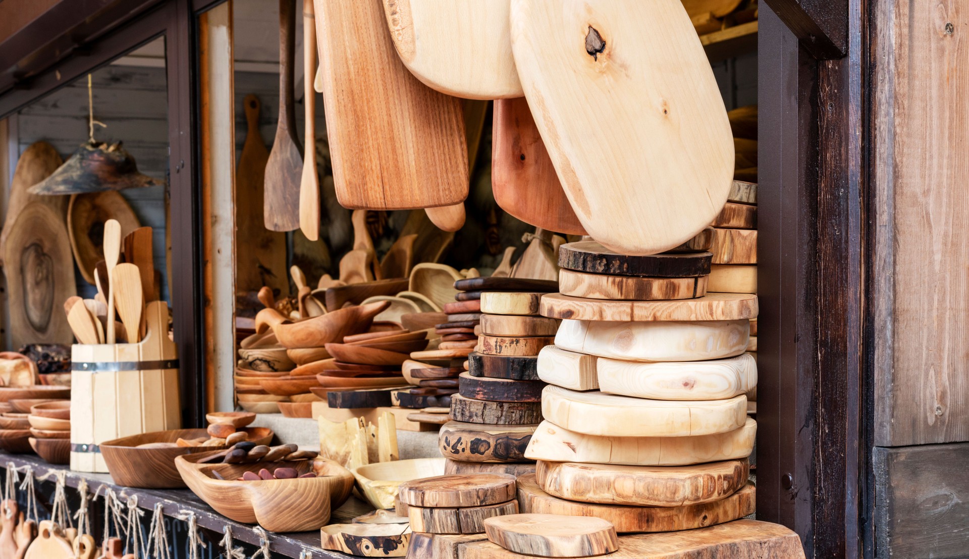 Market with wooden cutting boards woodenware from various types of wood - beech, oak, pine, boxwood, ash, linden, homemade products for cooking